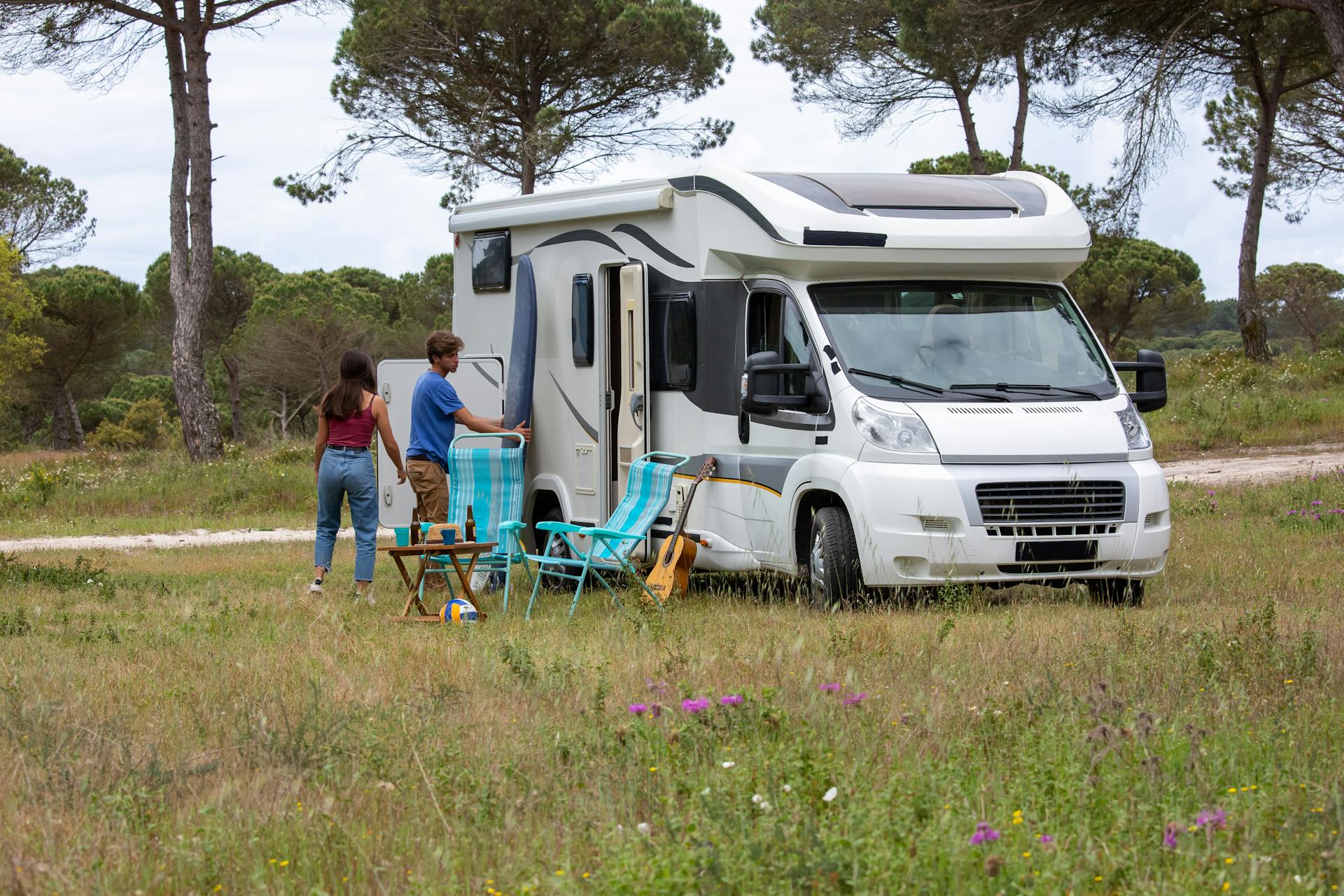Illustrative photo of an RV and outdoor seating among trees